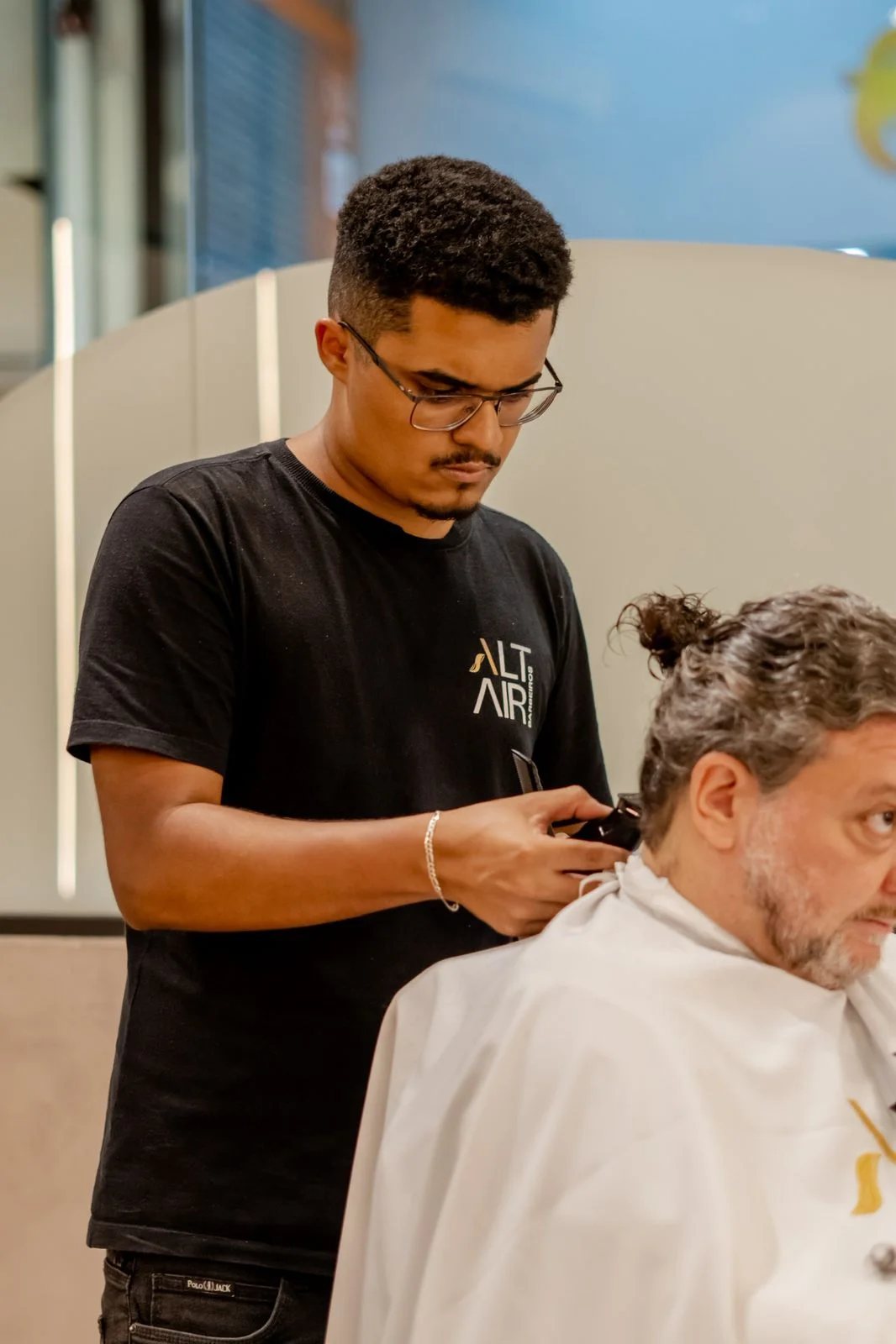 Barbeiro trabalhando no corte de um cliente