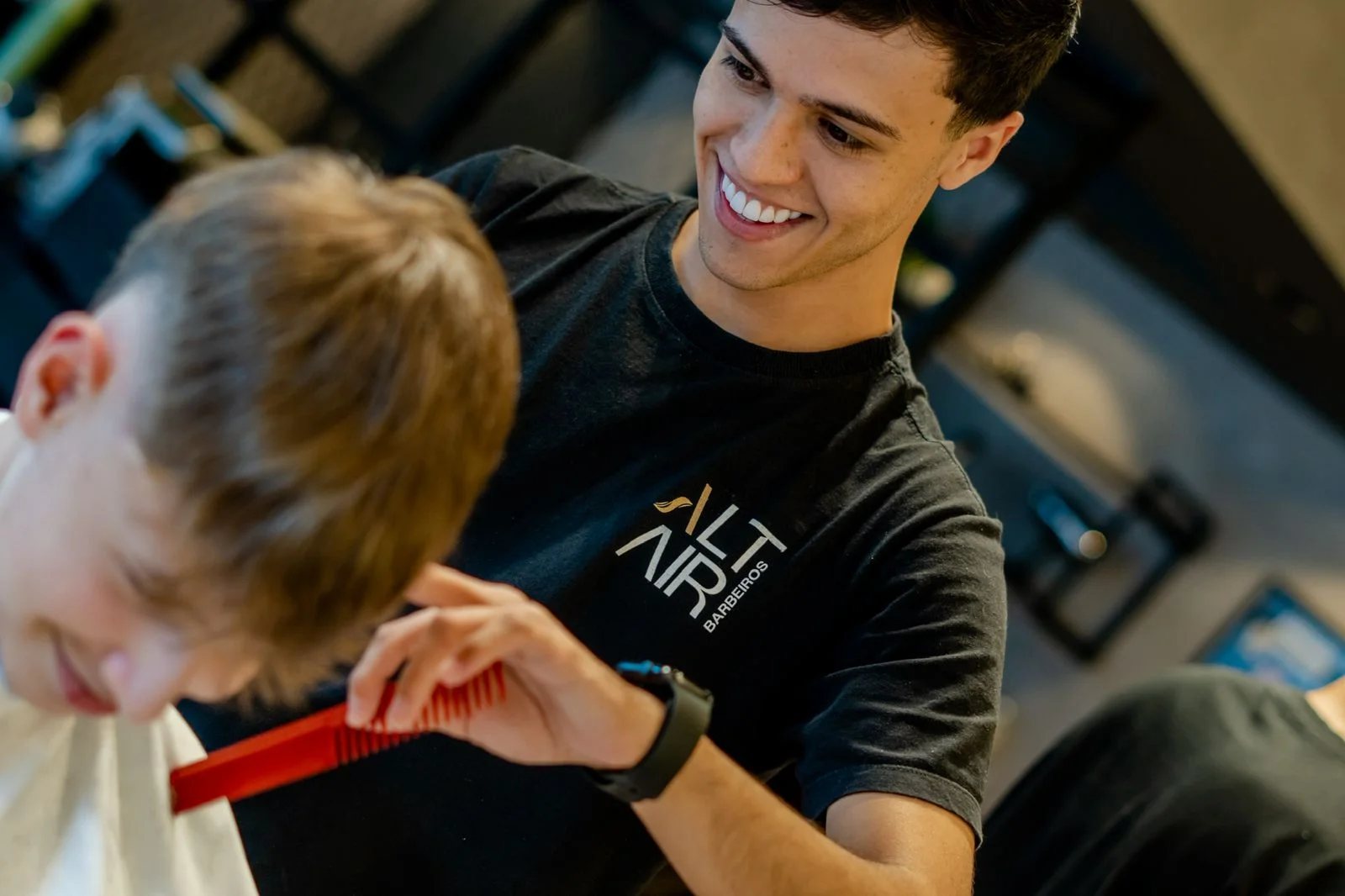 Barbeiro sorrindo durante o atendimento completo