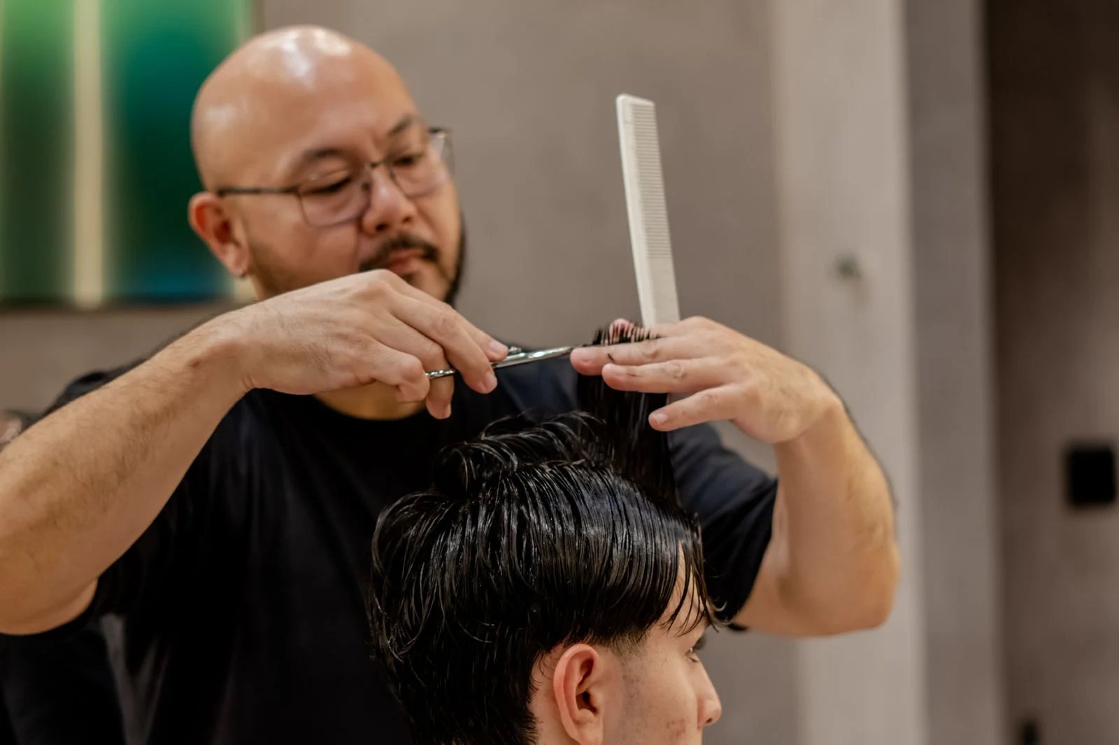 Barbeiro fazendo um corte com tesoura